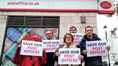 Lib Dem Activists outside kensington post office, holding a "Save our Post Offices" Sign