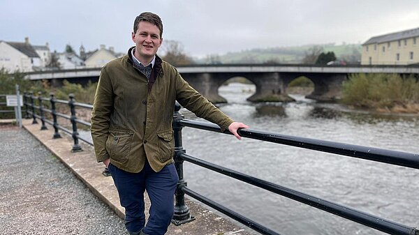 David standing in front of a river