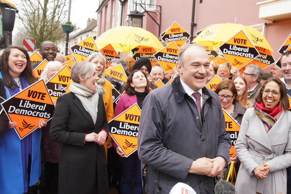 Ed Davey with laughing crowd holding Liberal Democrat diamond signs