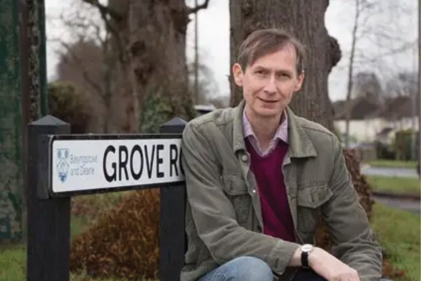 John McKay in front of road sign at Grove Road