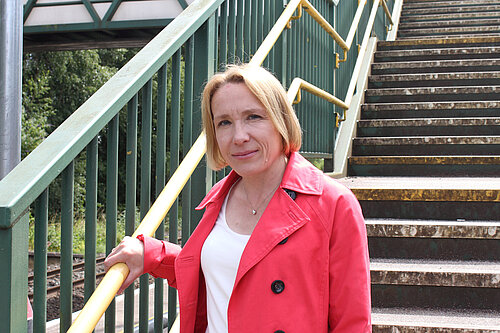 Helen standing in front of the stairs at Whitchurch Station