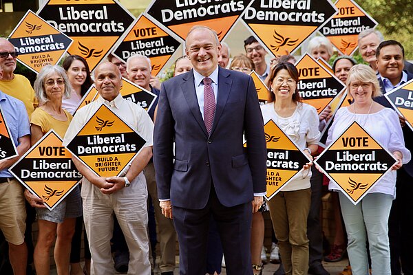 Ed Davey with a crowd holding Lib Dem signs