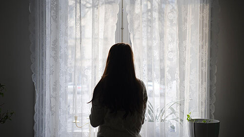 A woman looking out a window.