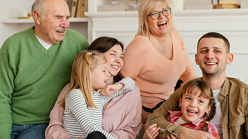 A smiling family with grandparents, parents and children