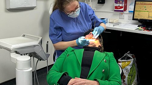 Pippa Heylings lying in a dentists chair while a dentist is inspecting her teeth