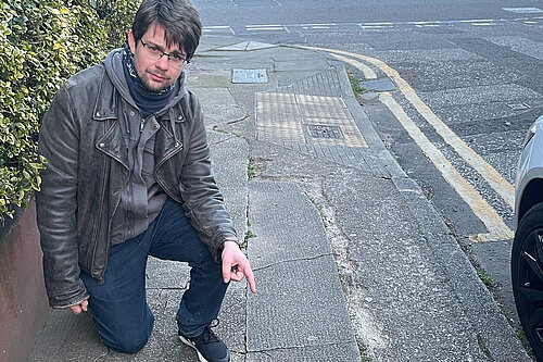 A man pointing at a pavement