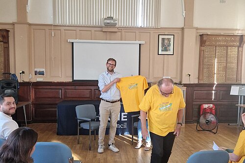 Freddie receiving a yellow Greenway campaign t-shirt at Thame Environment Forum 
