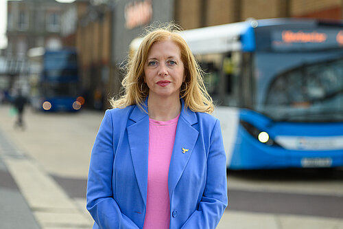 Liz Jarvis MP standing infront of a bus