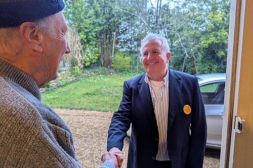 Trevor shaking hands with a local resident