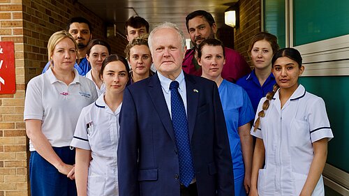Clive Jones outside the RBH surrounded by NHS Staff