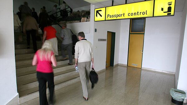 People going up a staircase to passport control.