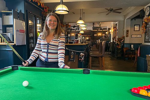 Vikki stood at a pool table in a local pub