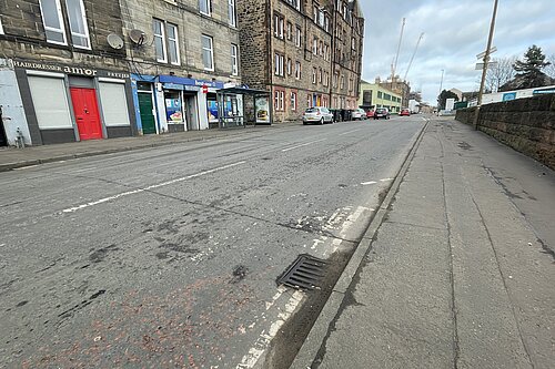 A street with a row of tenements in the background