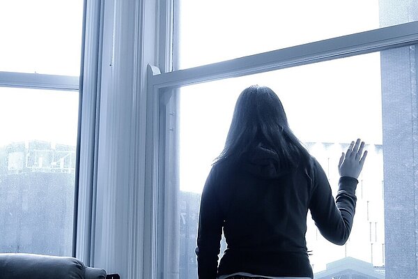 Black and white image of woman at a window