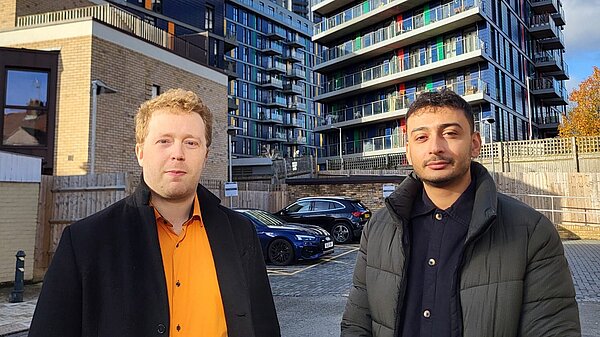 Charlie Clinton and Anton Georgiou in front of a tower block