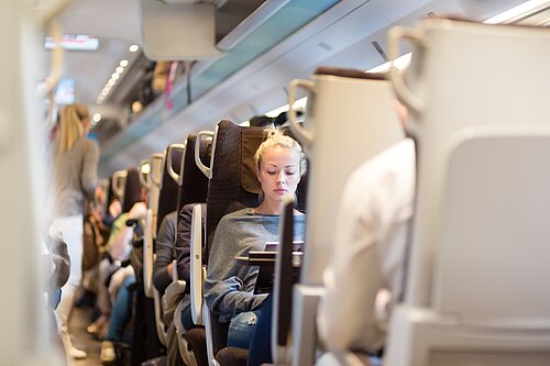 Lady sitting on a train.