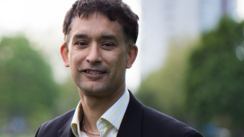 Dave Raval standing in front of a new block of flats