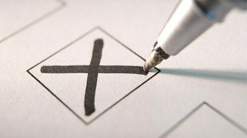 A pen marking an X vote in a box