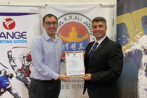Tom Gordon MP receiving a certificate from Kambiz R. Ali Master 