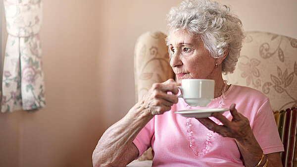 Winter Care packages An elderly lady smiling whilst holding a cup of tea.
