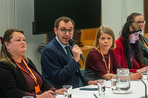 Tom Gordon talking into a mic at a table of people
