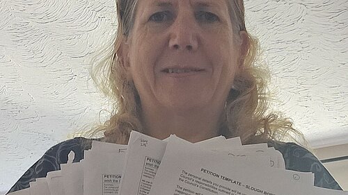 Jen Simpson with paper versions of petition submitted