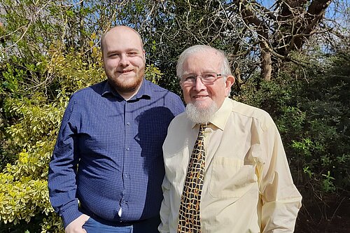 Connor Docwra stood on the left with Gareth Wilson on the right, in front of treet and bushes