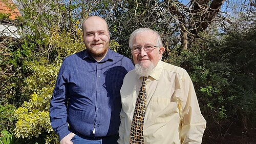 Connor Docwra stood on the left with Gareth Wilson on the right, in front of treet and bushes