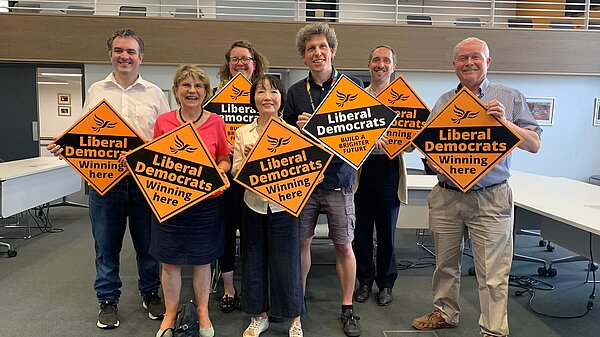A group of Lib Dems holding up posters