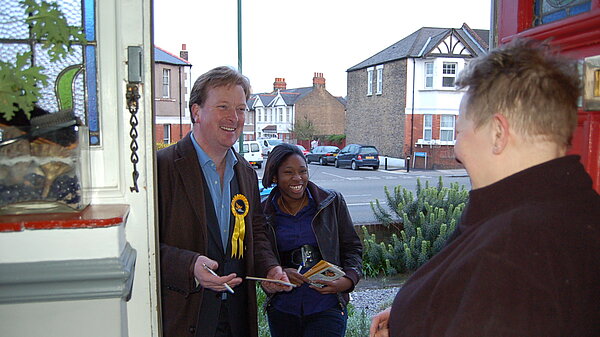 Two Lib Dem activists speaking to a resident on the doorstep