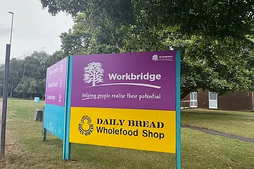 Photo of a purple sign with the text Workbridge on a purple background