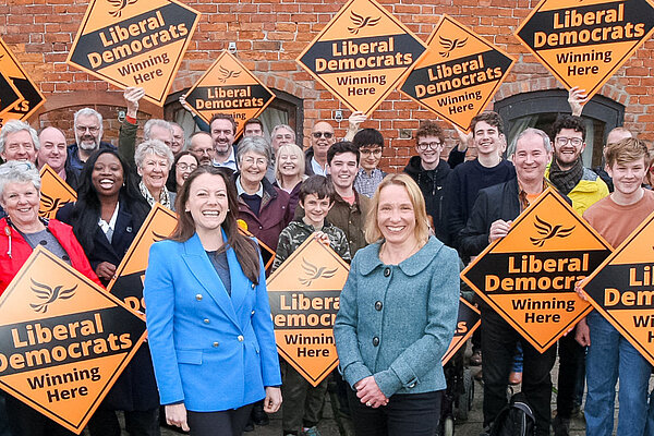 Sarah Green and Helen Morgan Sarah Green and Helen Morgan in front of a crowd holding Liberal Democrat posters
