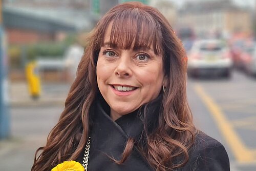 A picture of Lizzie Fox wearing the LibDem rosette.