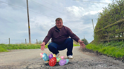 Jack posing in front of an Easter egg filled pothole