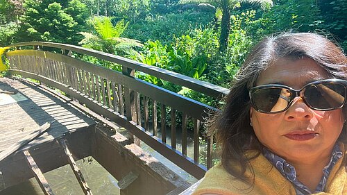 Gita Bapat standing in front of bridge in Kelsey Park