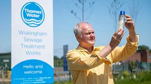 Clive Jones at the Thames Water Sewage treatment plant looking at a sample of dirty looking water