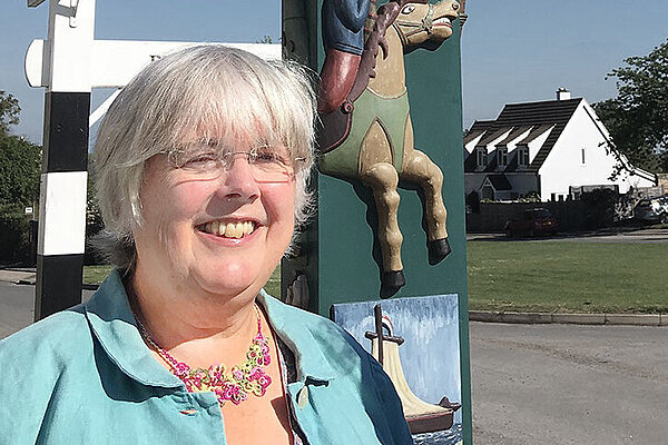 Charlotte Cane stood in front of Reach Village sign