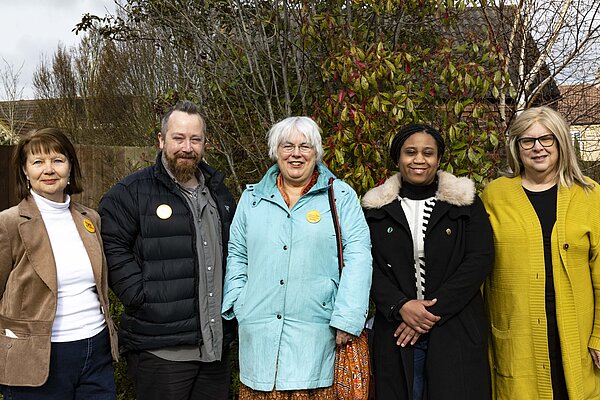 Group of Lib Dem candidates stood in front green bushes