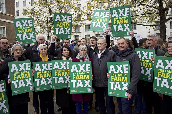 Liberal Democrat MPs attend the Family Farm Tax protest, holding signs with the text "Axe the Family Farm Tax"