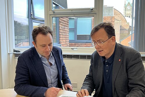 Danny Chambers MP and Martin Tod sitting in an office discussing a document