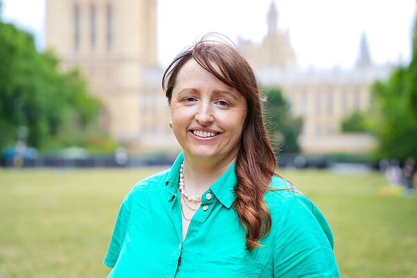 Rhiannon Leaman stands in front of the Houses of Parliament