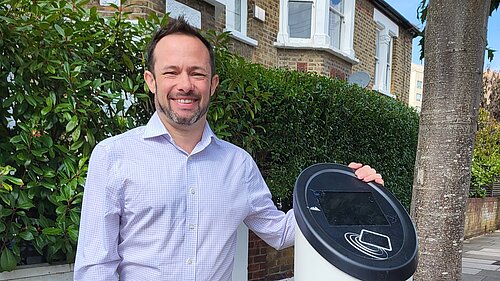 Cllr Gary Malcolm stood next to an EV charging station.