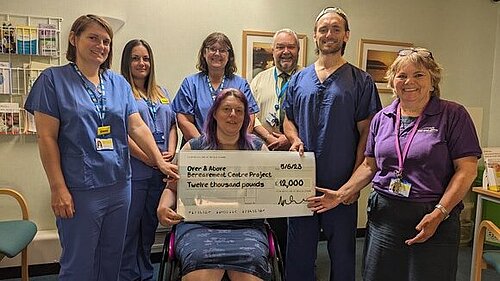 Image off Cllr. Helen Walker presenting cheque for £12,000 to membes of North Devon District Hospital Over-and-Above team.