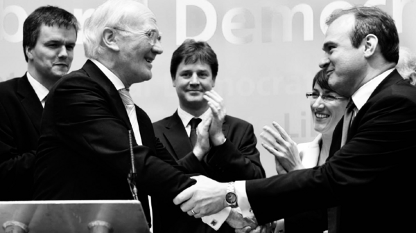 Black and white photo of Liberal Democrats, including Menzies Campbell, Nick Clegg and Ed Davey, and the Legacy Society logo