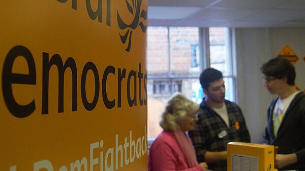 People in conversation at Liberal Democrat event