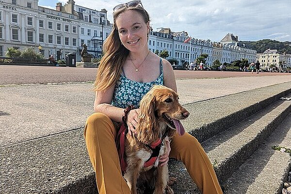 Rachaela and Goldie sitting on the promenade in Llandudno