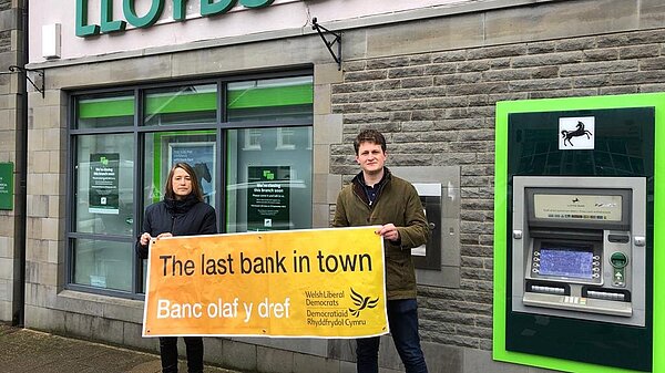 Jane Dodds MS and David Chadwick MP holding a banner saying save our banks