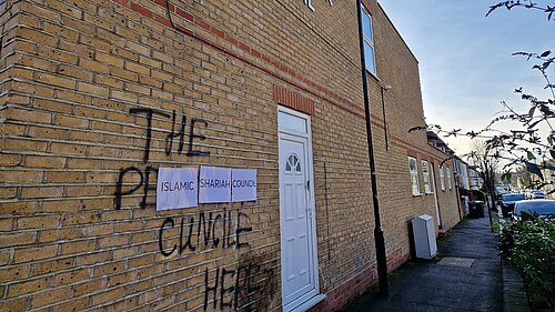 Graffiti spray-painted onto the wall of the Islamic Sharia Counil building in Leyton