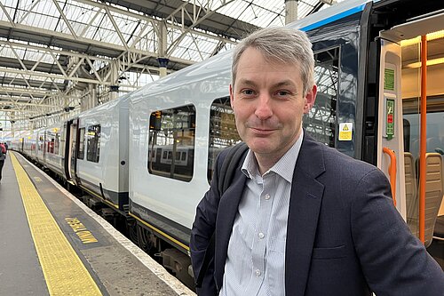 Will Forster at Waterloo with train behind him